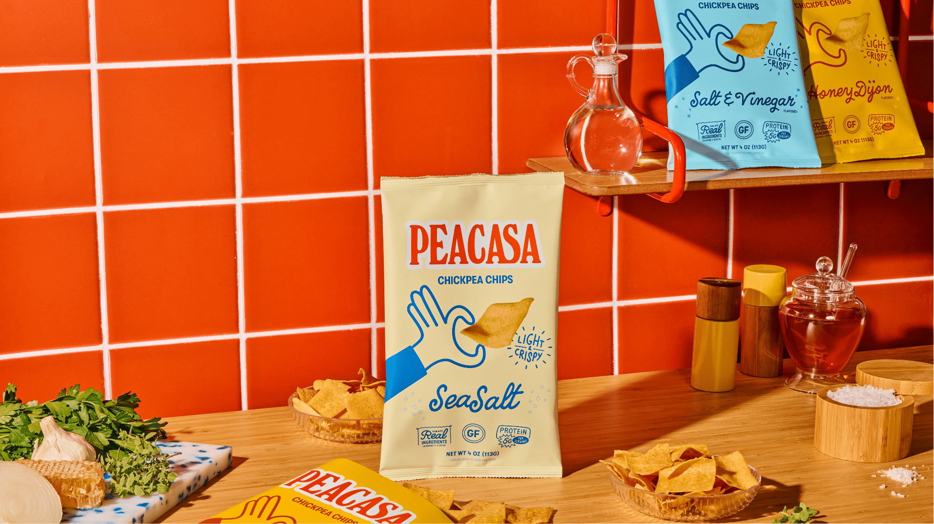 Bag of Peacasa chickpea chips on a counter with herbs, garlic, honey, and salt